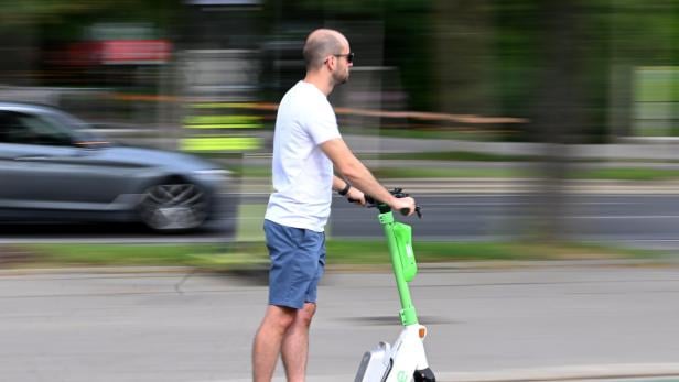 Mann auf E-Scooter ohne Helm