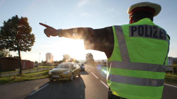 Ein Polizist regelt den Verkehr auf einer Landstraße.