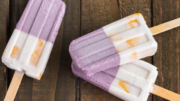 Drei Halo-Halo-Eis am Stiel liegen auf einem Holztisch.