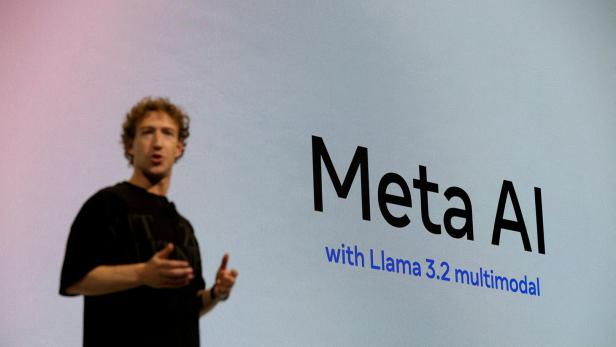 Mark Zuckerberg steht vor einer Videowall. Darauf steht "Meta AI with Llama 3.2 multimodal"