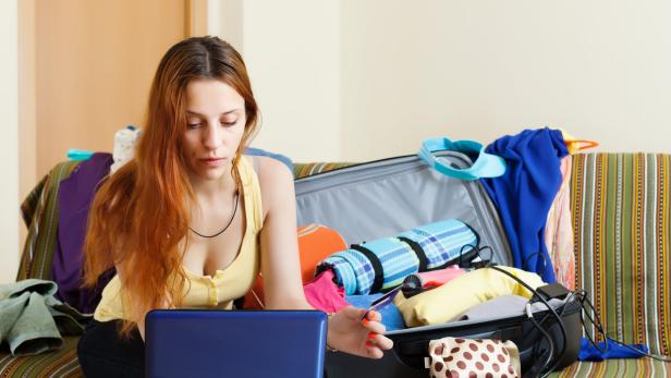 Eine Dame kontrolliert am Laptop ihre Ausgaben nach dem Urlaub