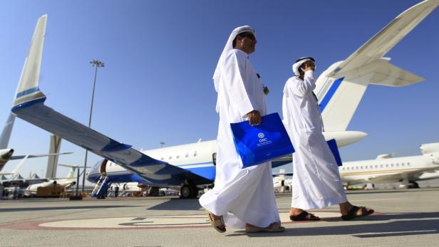 Visitors walk past aircraft on display during the