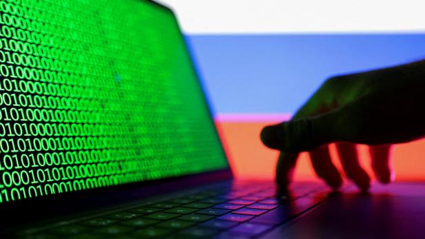 FILE PHOTO: Illustration shows laptop with binary code on the screen in front of Russian flag FILE PHOTO: Illustration shows laptop with binary code on the screen in front of Russian flag