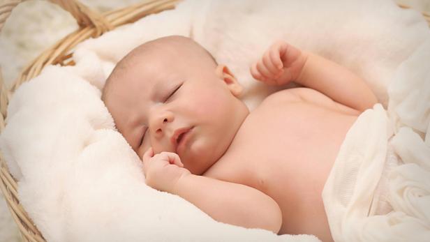 Baby liegt in Körbchen