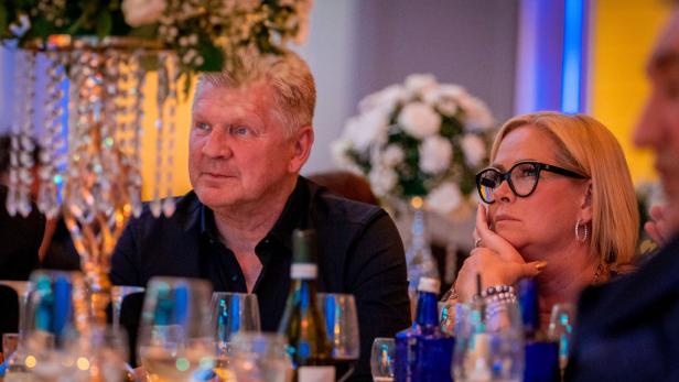 Claudia und Steffen Effenberg sitzen in einem elegant dekorierten Raum an einem Tisch mit Getränken