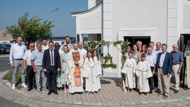 Eine Gruppe von Menschen vor der Kirche in Neudorf nach der Heiligen Messe.