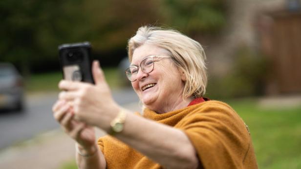 Frau mit Smartphone in Park.