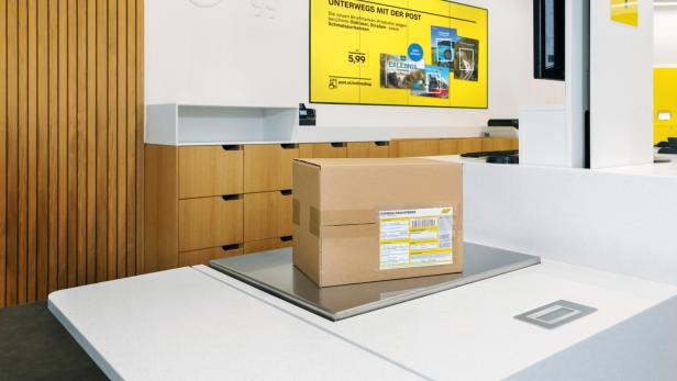 Paket auf einer Waage am Tresen einer Post-Filiale.