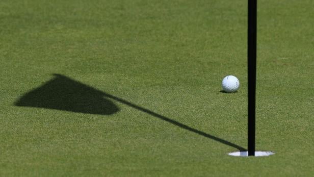 Ein Golfball, der in der Nähe des Loches liegt.