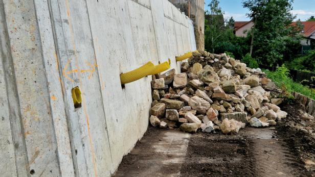 Hanggrundstück mit Mauer aus Beton und Drainage-Abläufen. 