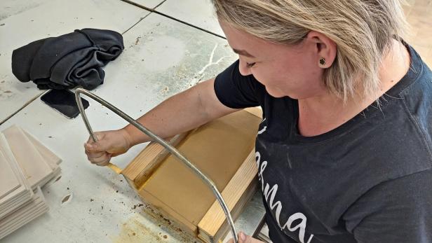 Frau bearbeitet ein Werkstück