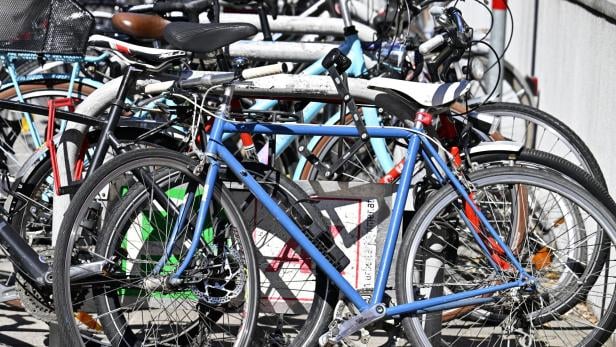Viele Fahrräder stehen an einem Fahrradständer.