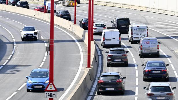 Autos und Lieferwagen fahren auf einer Autobahn.