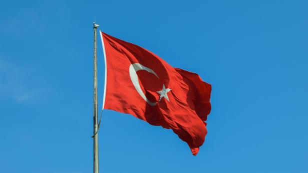 Rot-weiße türkische Flagge weht an einem Fahnenmasten.