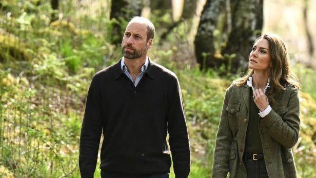 Prinz William und Prinzessin Kate. Sie spazieren im Wald.