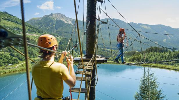 Zwei Personen gehen in Kletterpark über See