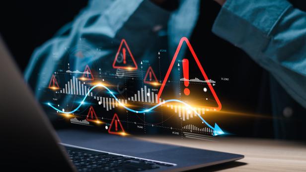 Businessman use laptop with virtual world economic growth chart with red warning sign for caution in investing economic situation warning, Business investment risks.