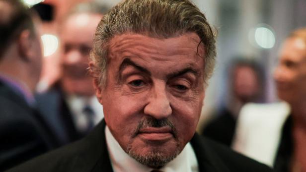 Sylvester Stallone, im verschwommenen Hintergrund Männer