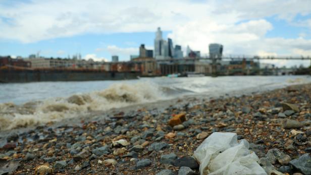 A plastic bag lies at low tide on the banks of the River Thames