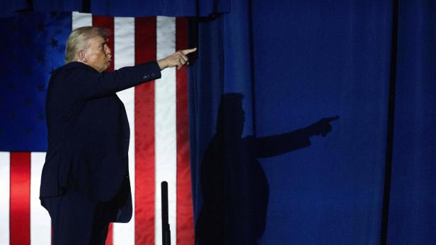 TOPSHOT-US-POLITICS-TRUMP Trump vor US-Flagge, sein Schatten im Hintergrund