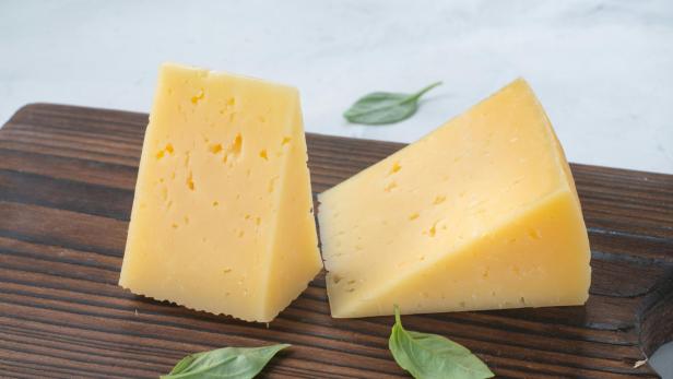 Zwei Stück Käse auf einem Holzbrett