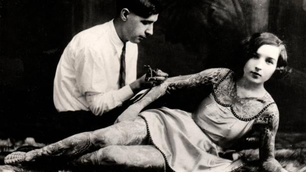 Tattoo Das Aufkommen lockererer Kleidungsstandards machte Tätowierungen in den 1920er-Jahren bei Frauen sichtbar. Zu jener Zeit waren unter anderem „tätowierte“ Strumpfbänder angesagt.
