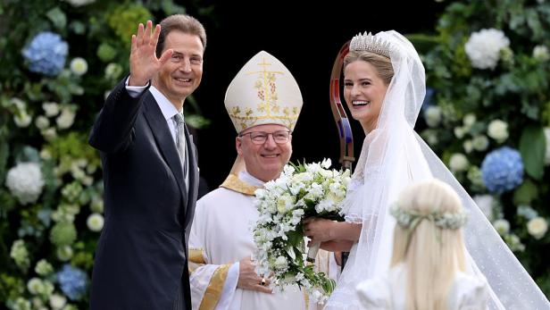 Erbprinz Alois mit seiner Tochter Prinzessin Marie Caroline und Bischof Benno Elbs. Alois winkt, die Braut trägt ein weißes Kleid mit Tiara und langem Schleier.