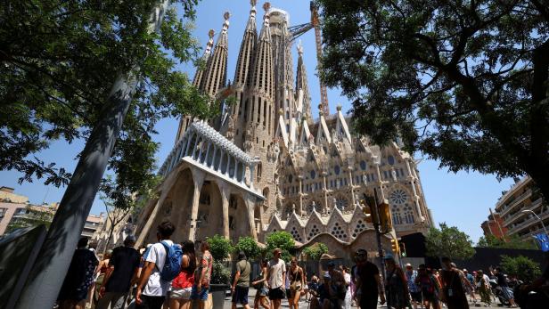 FILE PHOTO: Groups of tourists walk around Sagrada Familia Basilica during a heatwave