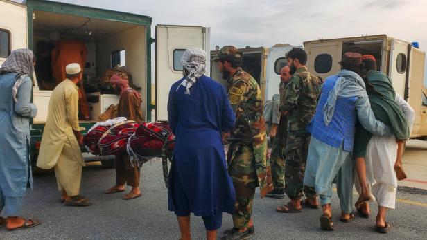 Taliban soldiers and civilians carry earthquake victims to an ambulance at an airport in Jalalabad Taliban soldiers and civilians carry earthquake victims to an ambulance at an airport in Jalalabad