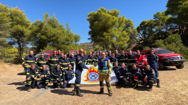 Feuerwehrleute vor Autos