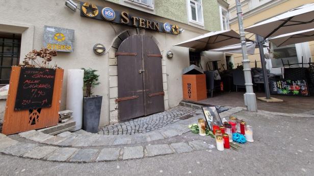 Kerzen stehen vor dem Eingan eines Lokals