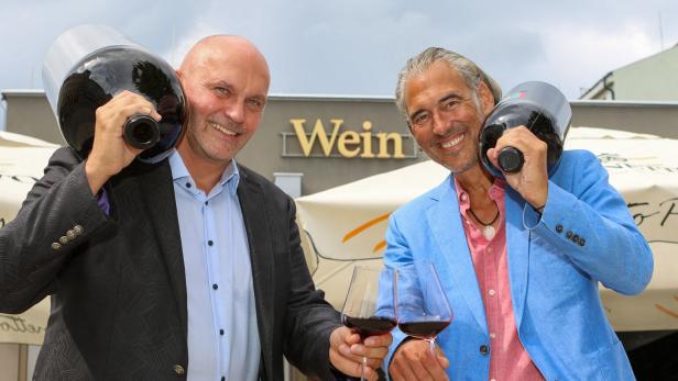 46-218284650 Organisatoren einer Weinmesse mit übergroßen Weinflaschen und Gläsern in der Hand