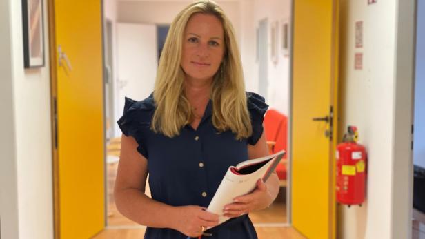 Claudia Holub im Vereinsbüro mit einer Mappe in der Hand.