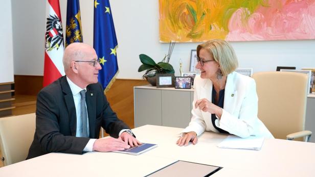 46-218267841 Friedrich Faulhammer und Johanna Mikl-Leitner sitzen an einem Schreibtisch und unterhalten sich.