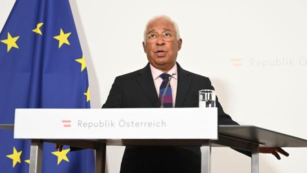 António Costa spricht vor einer EU-Flagge und einem Schild mit der Aufschrift „Republik Österreich“.