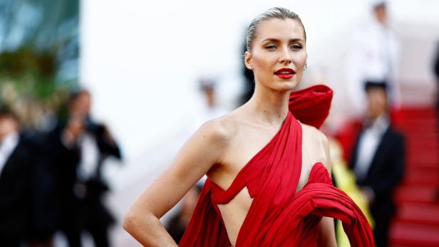 Lena Gercke posiert in einem roten Kleid auf einem roten Teppich.