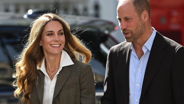 Prinzessin Kate und Prinz William Kate und William gehen nebeneinander, sie lächelt, er spricht.