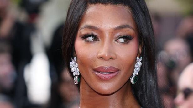 Naomi Campbell Naomi Campbell trägt ein weißes Kleid und auffällige Ohrringe.