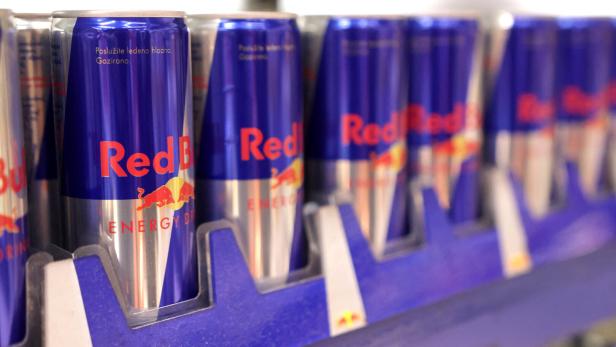 Cans of Red Bull Energy Drink are displayed on a shelf in a supermarket