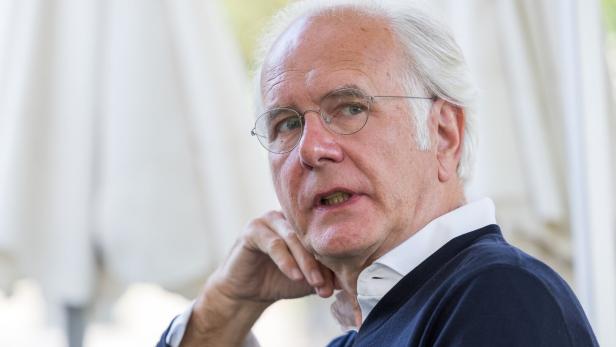 Harald Schmidt Harald Schmidt sitzt seitlich und blickt nachdenklich zur Seite.
