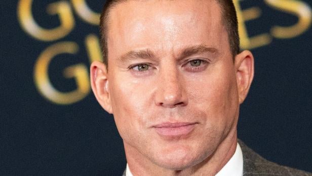 Channing Tatum Eine Nahaufnahme von Channing Tatum vor einem dunklen Hintergrund mit goldenen Buchstaben.