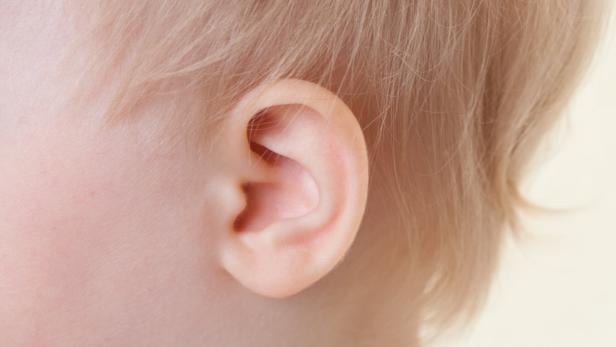 Das Bild zeigt ein Ohr eines Kleinkindes. Für Kinder mit einer Hörbeeinträchtigung ist das bewusste sprachliche Miteinander in der Familie ganz wichtig.