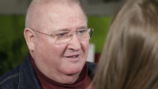 Horst Krause in einem roten Shirt und einer blauen Jacke. Er blickt zur Seite. 
