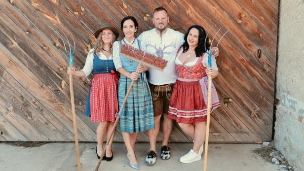 Vier "Bauer sucht Frau"-Kandidaten vor einer Hoftür mit Besen und Mistgabeln