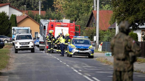 Soldiers patrol the street, following violations of Polish airspace during a Russian attack on Ukraine, in Wyryki Mehrere Feuerwehrleute und Polizisten sperren eine Straße in einem Wohngebiet ab, ein Soldat steht im Vordergrund.