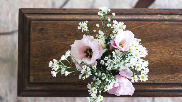 Als der Sarg seines verstorbenen Sohnes n die Kirche getragen wurde, erlitt ein Mann aus North Yorkshire einen tödlichen Herzinfarkt. Rosa Blumen auf einem Sarg