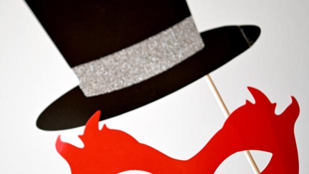 Silvester- und Neujahrsdekoration mit einem Zylinder und einer roten Maske.