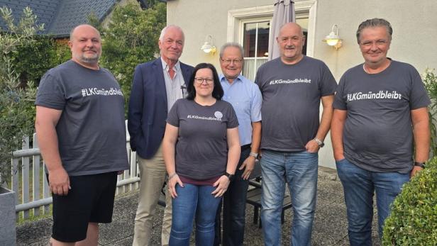 Ein Gruppenfoto, dass einzelne Vereinsmittglieder zeigt. Sie tragen graue T-Shirts mit der Aufschrift "LK Gmünd bleibt" und stehen im Freien vor einem Haus.