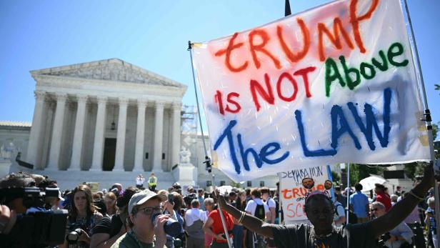 FILES-US-VOTE-JUSTICE-TRUMP Ein Demonstrant hält vor dem Supreme Court in Washington ein Schild hoch auf dem steht: "Trump steht nicht über dem Gesetz"
