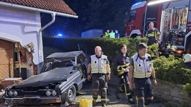 Oldtimer-Wrack vor Hausmauer.